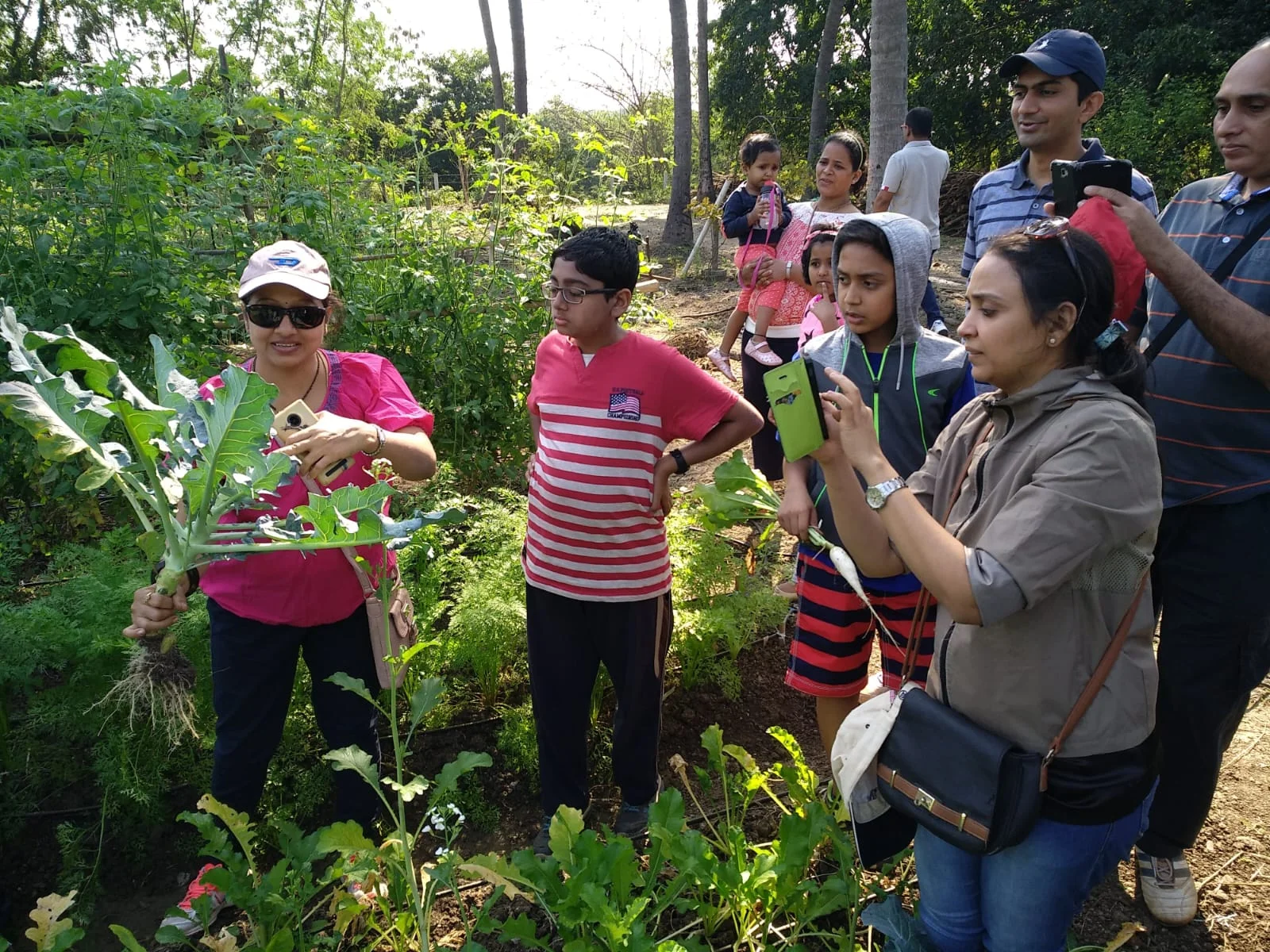 Families exploring the organic vegetable garden during a guided farm tour at Save Farm